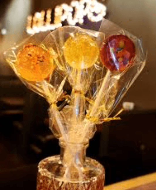 Wrapped lollipops with the Lollipops sign in the background