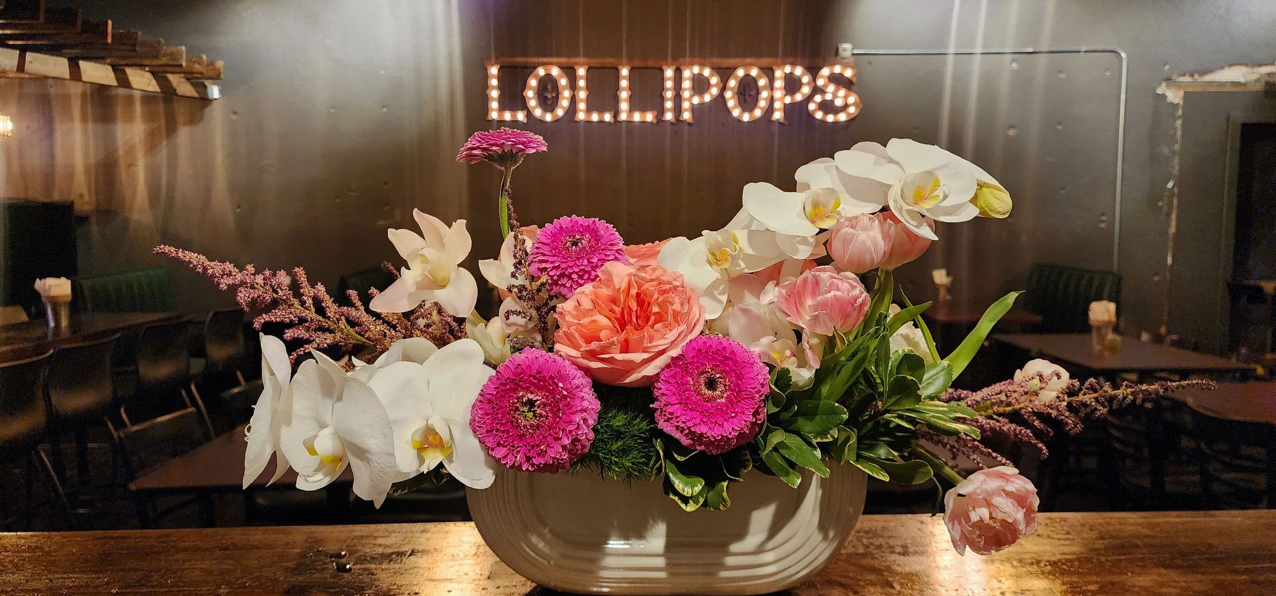 Flowers and warm dining room at Lollipops Woodfire and Grocery