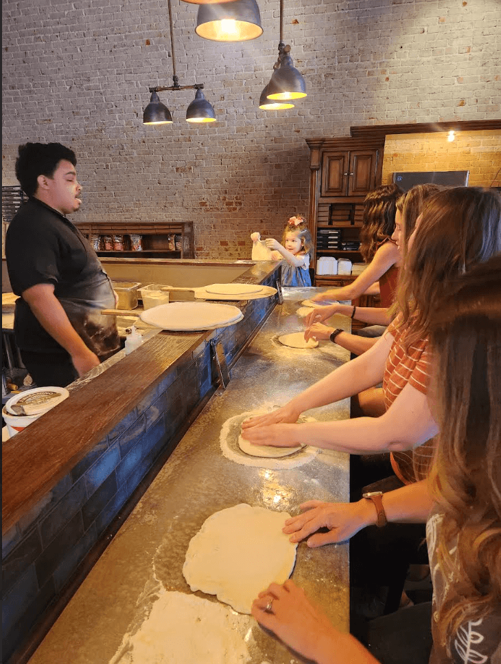 Guests making pizza during a Lollipops pizza class